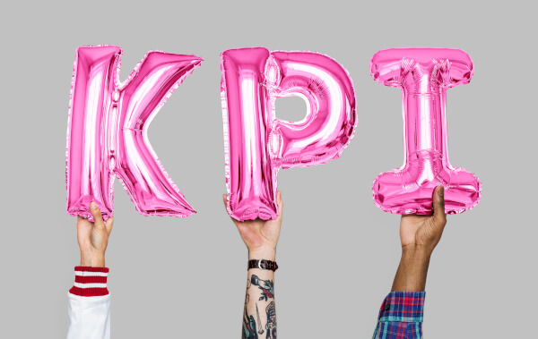 Hands holding pink letters spelling KPI